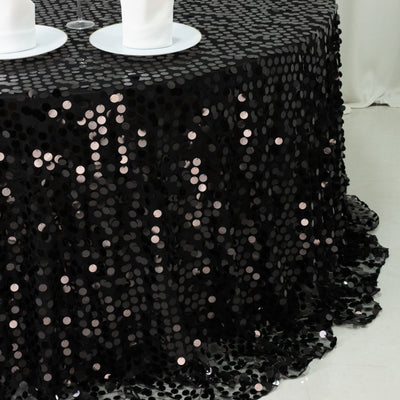 Black sequin tablecloth with circular embellishments draping elegantly over a table.