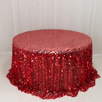 Red sequin tablecloth with a shimmering finish on a round table.