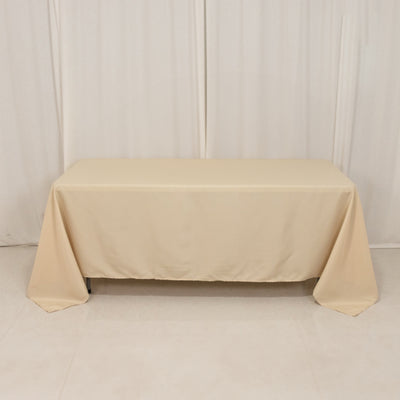 Beige tablecloth draped over a table in a studio setting.