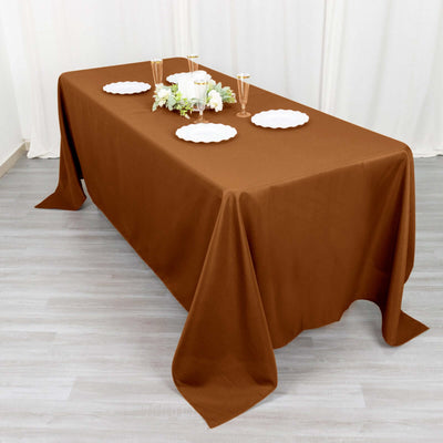 Brown tablecloth draped over a table set with plates and glassware.