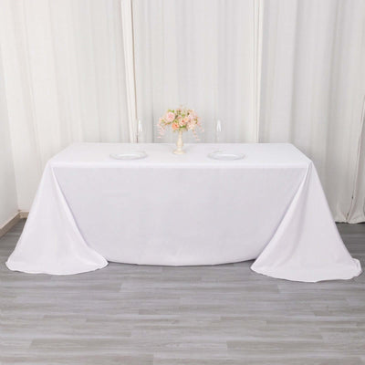 Elegant white tablecloth draped over a table with floral centerpiece.