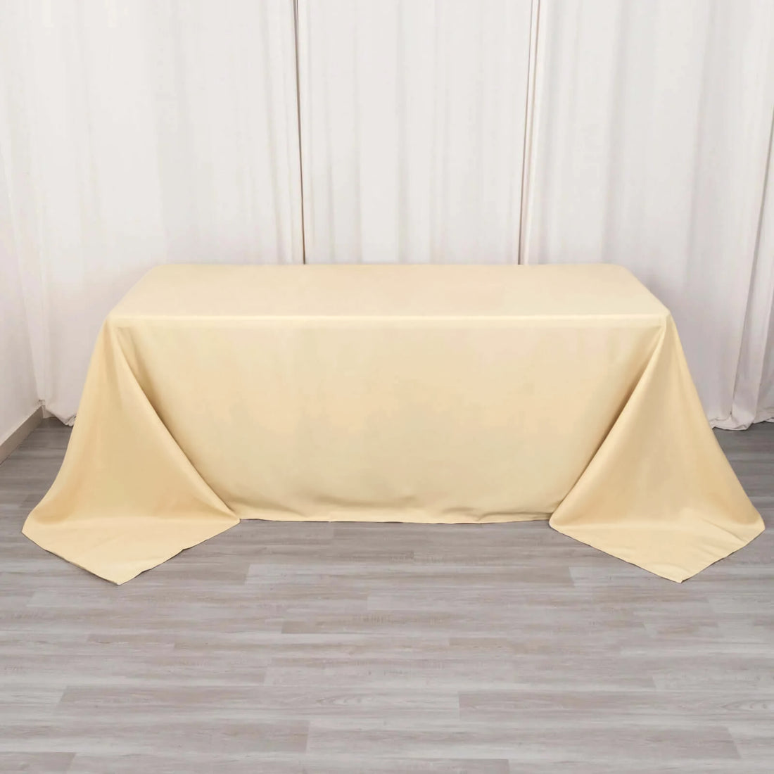 Beige tablecloth draped over a table on a neutral backdrop.