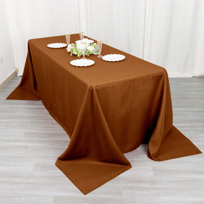 Brown tablecloth draped elegantly over a dining table with decorative plates and flowers.