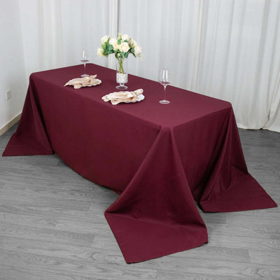 Burgundy tablecloth draped elegantly over a dining table with floral centerpiece.