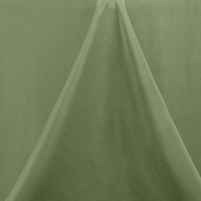Green fabric draped elegantly on a plain backdrop.