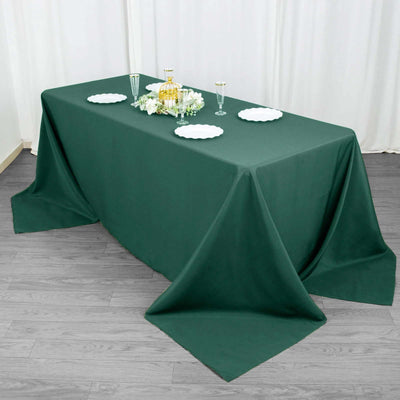 Green tablecloth draped over a table set for a formal event.