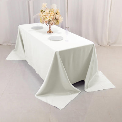 Elegant white tablecloth draped on a table with floral centerpiece and dinnerware.