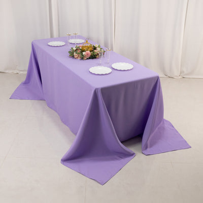 Lavender tablecloth draped elegantly over a table with decorative plates and flowers.