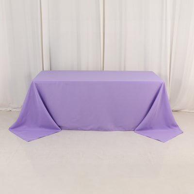 Purple tablecloth on a smooth surface with soft drapes in the background.
