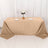 Beige tablecloth draped over a table with plates and a vase of flowers.