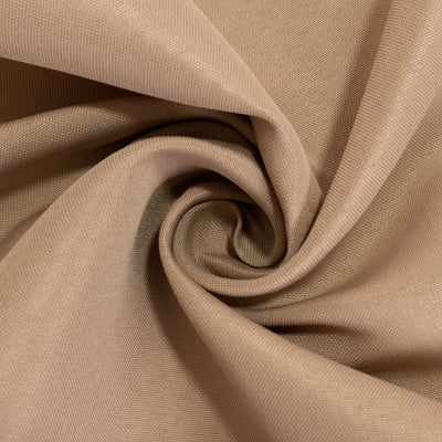 Close-up of soft, textured beige fabric in a swirling pattern.