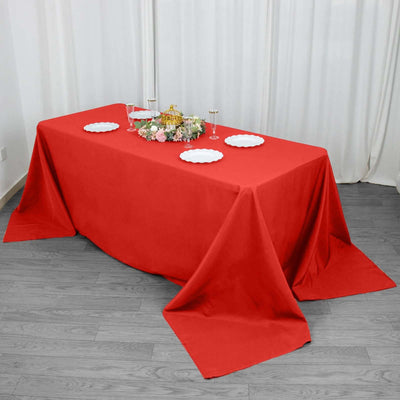 Red tablecloth draped elegantly over a table set for a meal.