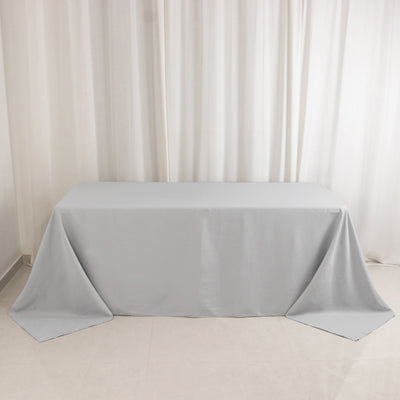 Gray tablecloth draped over a table on a neutral backdrop.