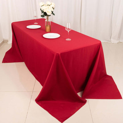 Red tablecloth draped elegantly over a table set for dining.