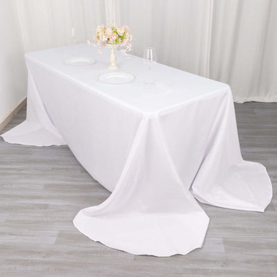 White tablecloth draped elegantly over a table set for dining.