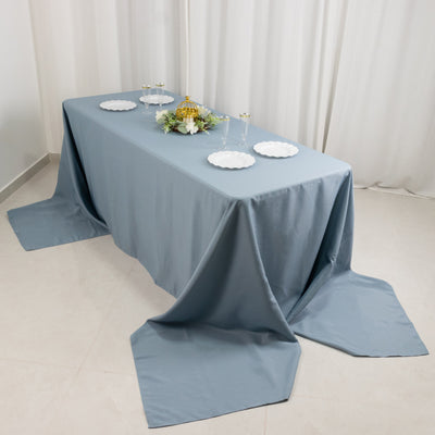 Elegant blue tablecloth draped over a table with plates and decorative items.