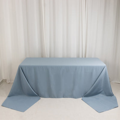 Blue tablecloth draped over a table on a plain backdrop.