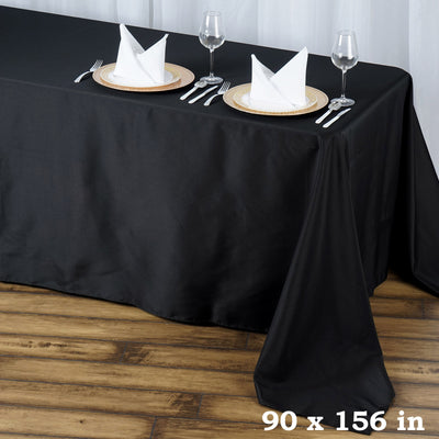 Black tablecloth measuring 90 x 156 inches, elegantly draped on a wooden table.