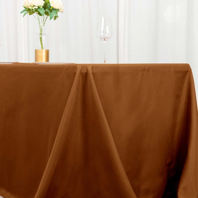 Brown tablecloth draped elegantly on a table with a glass and vase.