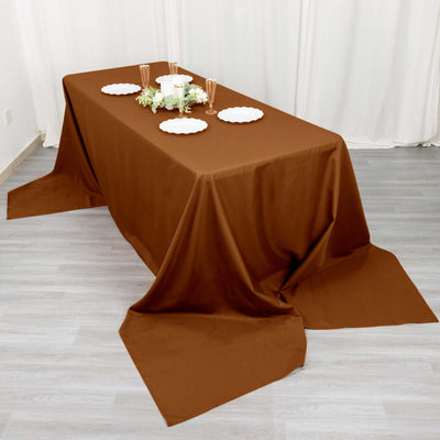 Brown tablecloth draped elegantly over a dining table with plates and decor.