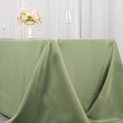 Green tablecloth draped elegantly over a table with floral centerpiece and wine glasses.