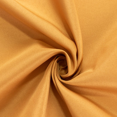 Close-up of soft, golden-orange fabric showing smooth texture.