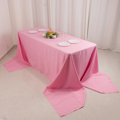 Pink tablecloth draped on a table with plates and decor for a stylish setting.