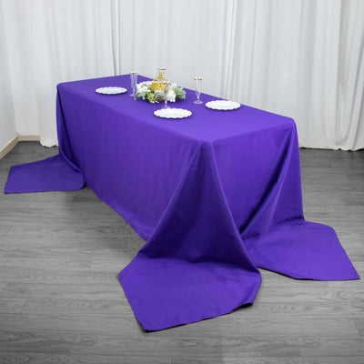 Purple tablecloth draped elegantly over a table with decorative plates and glasses.