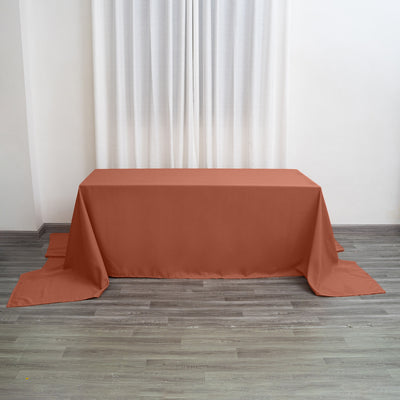 Rust-colored tablecloth draped over a table in a bright room setting.