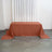Rust-colored tablecloth draped over a table in a bright room setting.