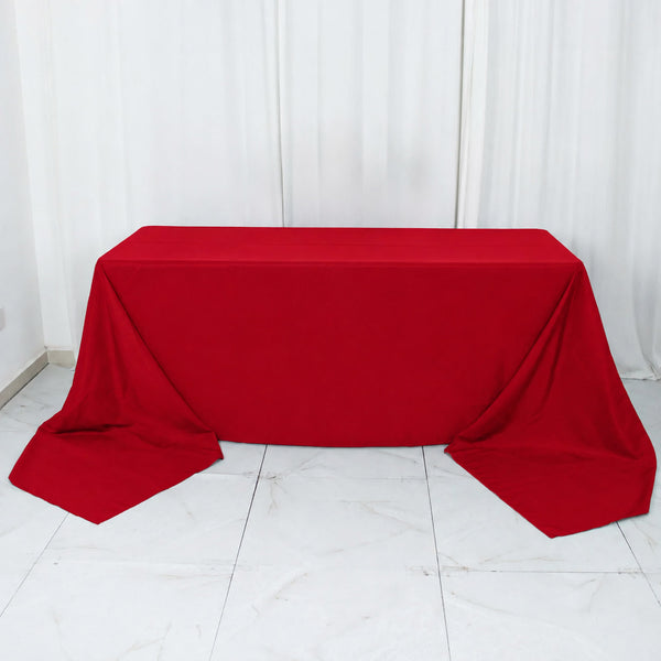 Red tablecloth draped over rectangular table in white room