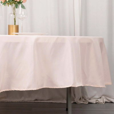 Elegant light pink tablecloth draping over a round table.