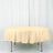 Round beige tablecloth draped over a table in a studio setting.