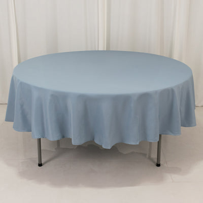 Round blue tablecloth draped over a table in a studio setting.