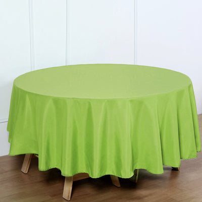 Round green tablecloth on a wooden table.