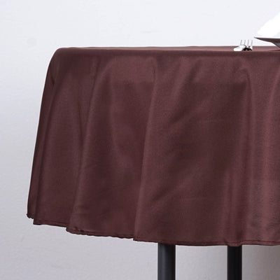 Brown tablecloth draped over a table with a fork on a plain background.
