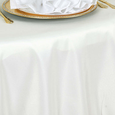 Elegant white tablecloth with gold-rimmed plate and neatly folded napkin.