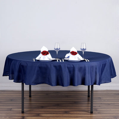 Elegant navy tablecloth with decorative napkins and glasses on a round table.