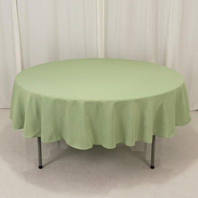 Round green tablecloth on a plain backdrop.