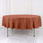 Round tablecloth in terracotta color on a round table.