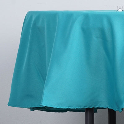 Teal tablecloth draped over a table, showcasing smooth fabric texture.