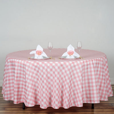 Pink gingham tablecloth on a round table set for dining.