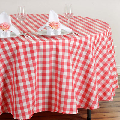 Red and white checkered tablecloth with plates and napkins on a dining table.