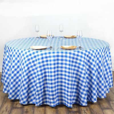 Blue and white checkered tablecloth draped over an oval table with glassware and plates.