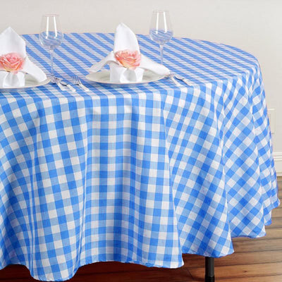 Blue and white checkered tablecloth with plates and glasses set for dining.