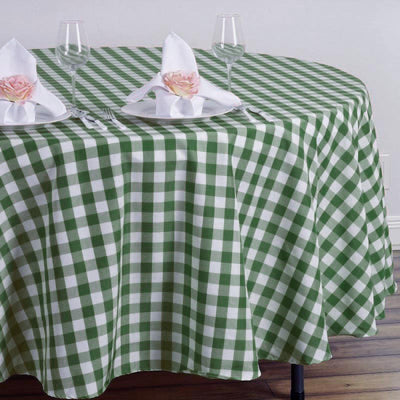 Green and white gingham tablecloth on a round table set with glasses and napkins.