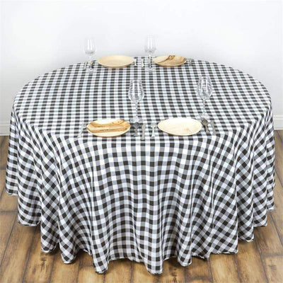Round black and white checkered tablecloth on a wooden table.