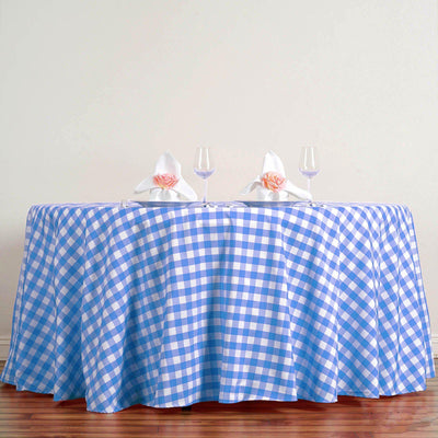 Blue and white gingham tablecloth on a round table with elegant napkin decor.