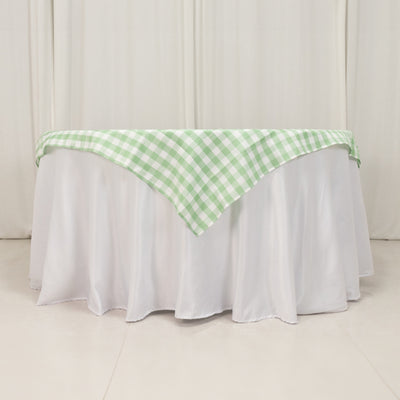 Green and white checked tablecloth draped over a white table.