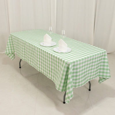 Green checkered tablecloth draped over a table with plates and napkins.